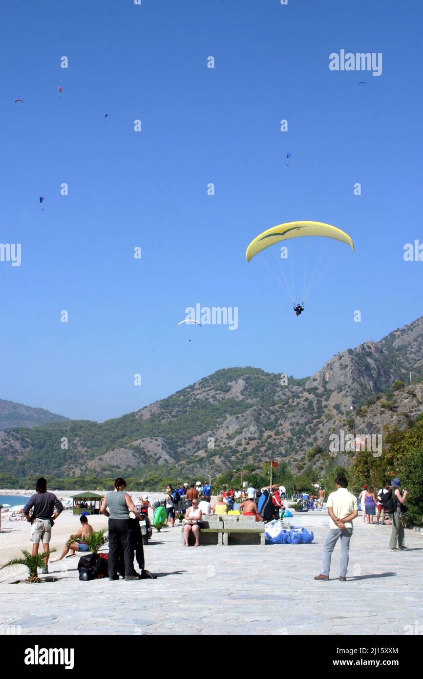 FETHIYE, TURKEY - OCTOBER 22: Paraglider landing to Fethiye Beach, October 22, 2003 in Fethiye, Turkey. Every year many paragliders attend to Fethiye Air Festival. Stock Photo