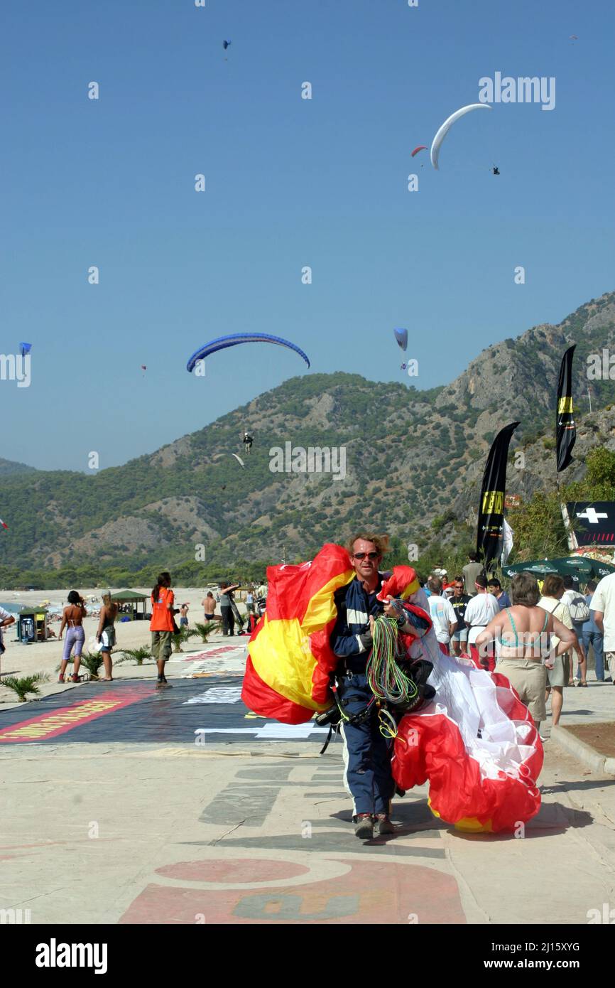 FETHIYE, TURKEY - OCTOBER 22: Paraglider carrying to parachute at Fethiye Beach, October 22, 2003 in Fethiye, Turkey. Every year many air sportsmen attend to Fethiye Air Festival. Stock Photo