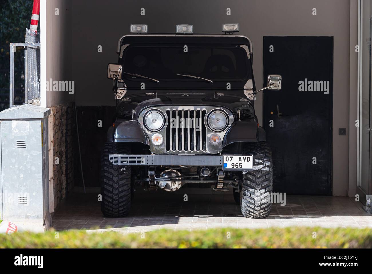 Side; Turkey – March 01 2022:  black Jeep CJ is parking  in the garage  on a  summer day Stock Photo