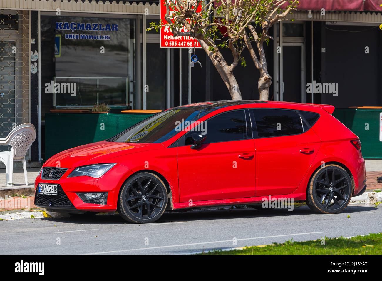 Side, Turkey – February 28 2022:   red Seat Leon  is parked  on the street on a warm summer day against the backdrop of a shops Stock Photo