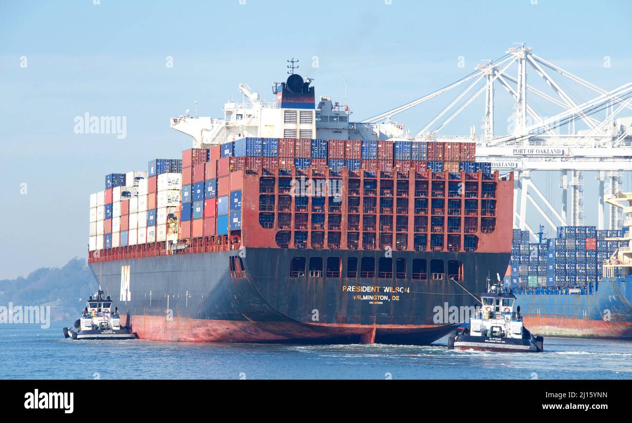 Oakland, CA - Jan 10, 2022: Multiple tugboats assisting APL cargo ship PRESIDENT WILSON to maneuver into the Port of Oakland. Stock Photo