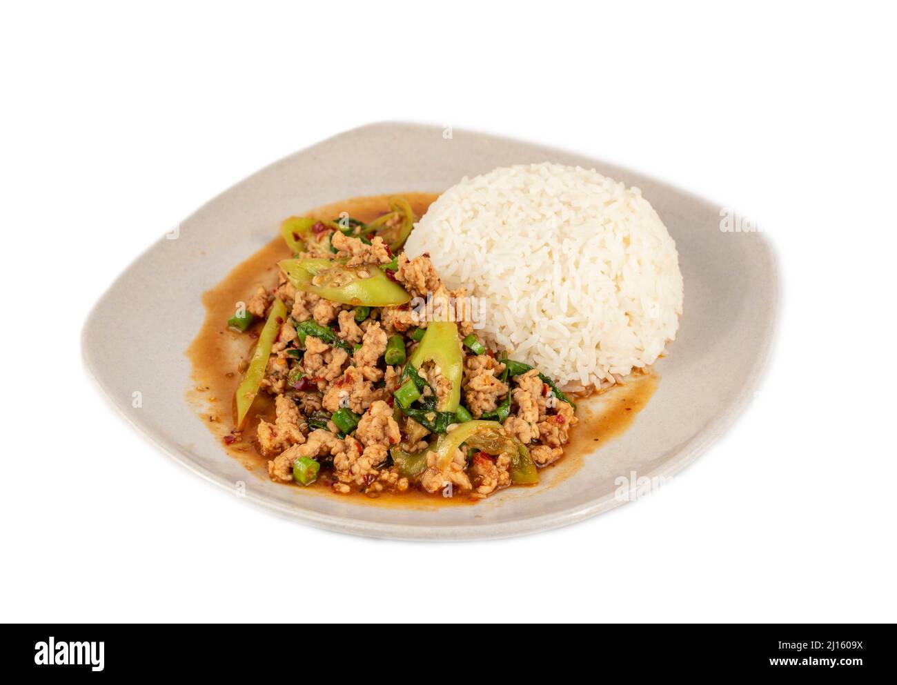 stir-fried minced pork fried chili pepper and  sweet basil served with steamed  rice on dish over white background Stock Photo