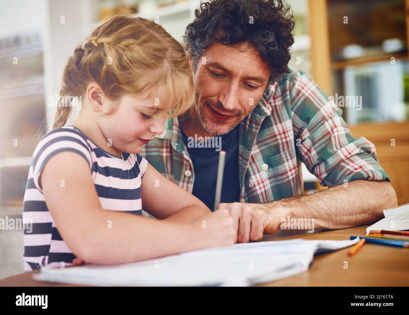 Dads always around to lend a hand with homework. Cropped shot of a father helping his daughter with her homework. Stock Photo