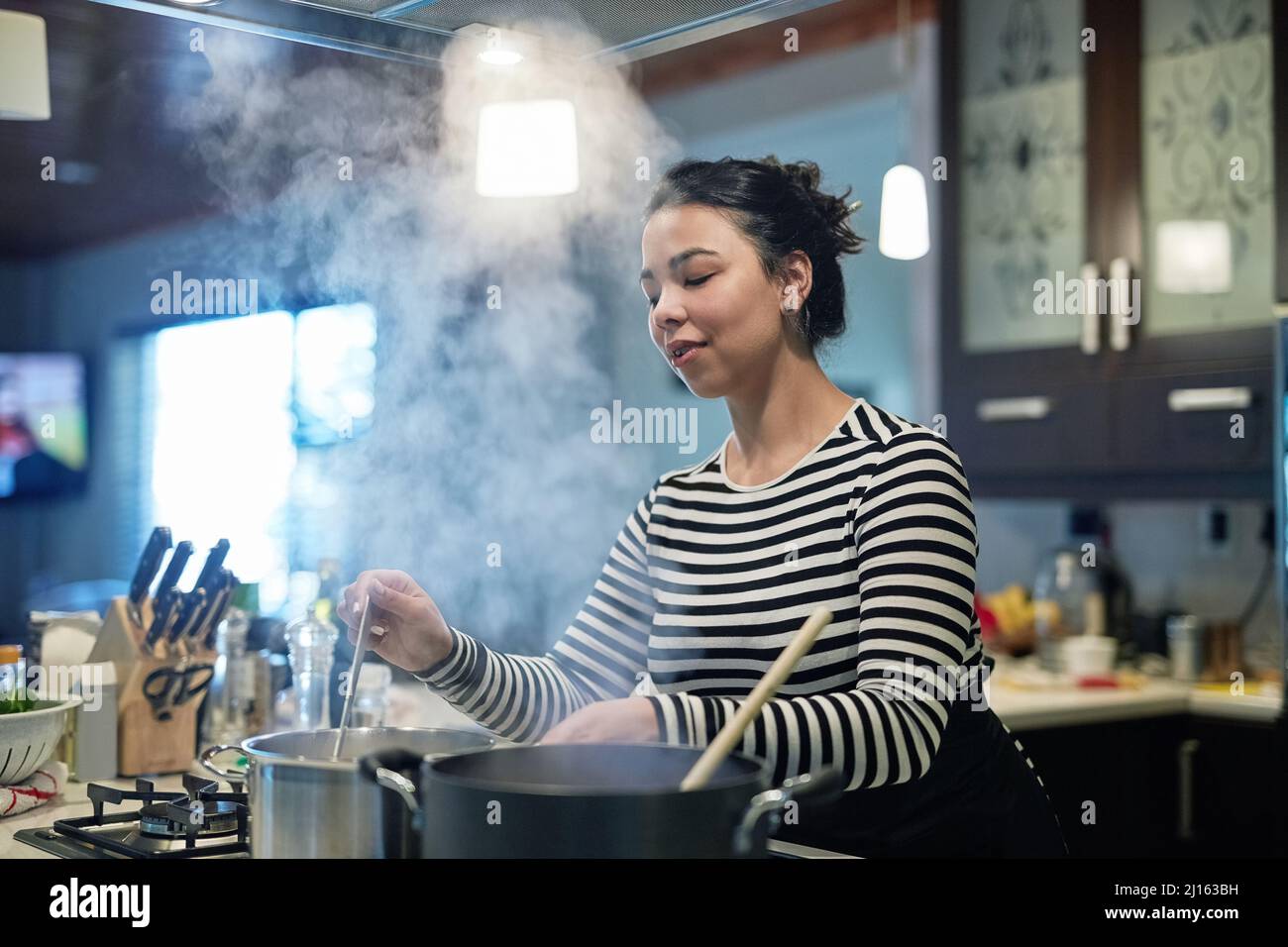 Young woman cooking in hi-res stock photography and images - Alamy
