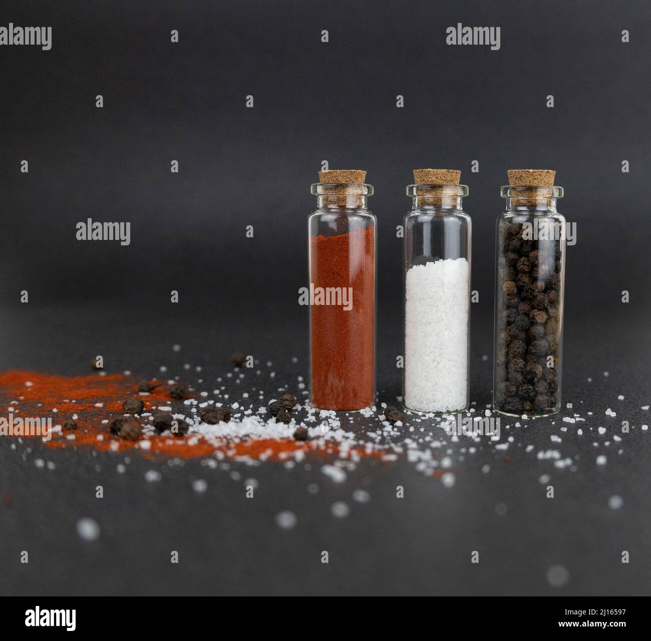 The sea salt, red ground pepper and black peppercorns in small glass