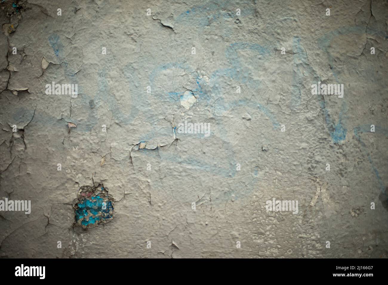 Old paint on wall. Texture of flying paint is gray. Simple background