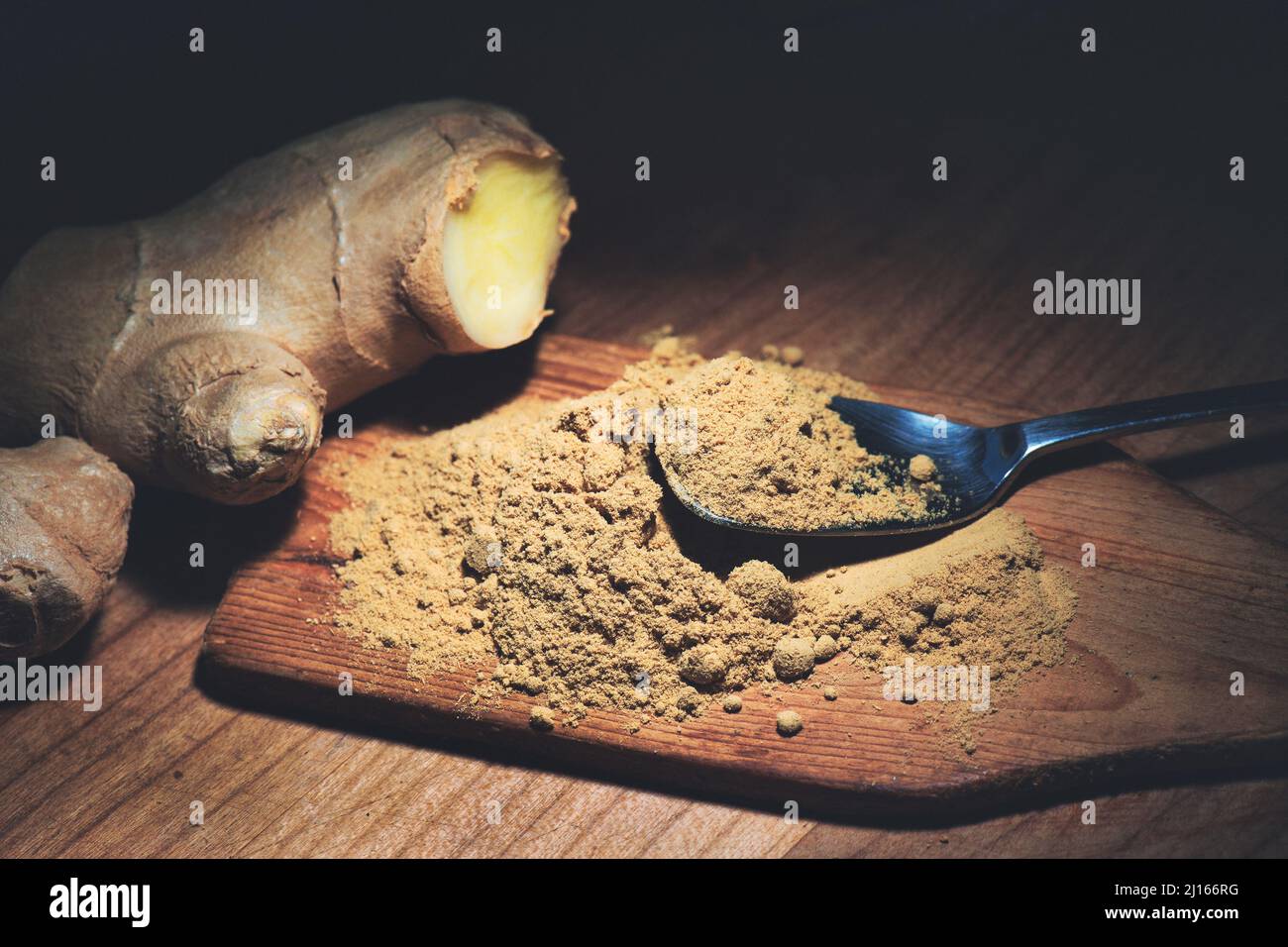 Ginger powder and ginger root on wooden kitchen table Stock Photo