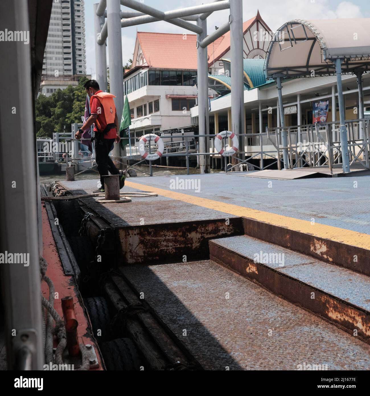 Worker on Orange Flag Express Boat Seaman Boatswain man on the ropes ...