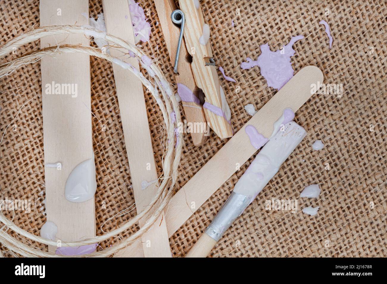 rustic hessian surface with pastel paint splatter and craft supplies ...