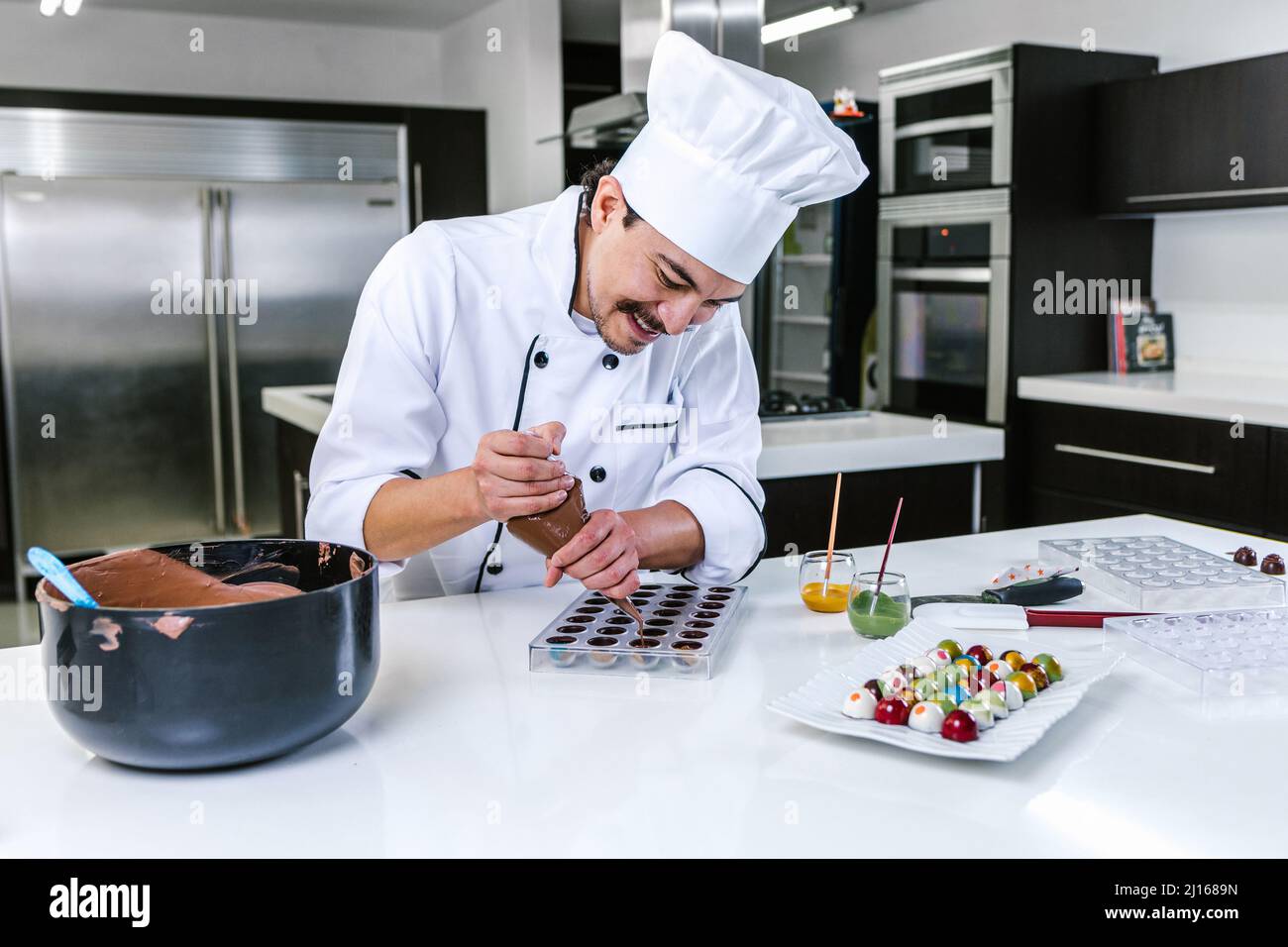 young latin man chocolatier in chef hat standing with mexican