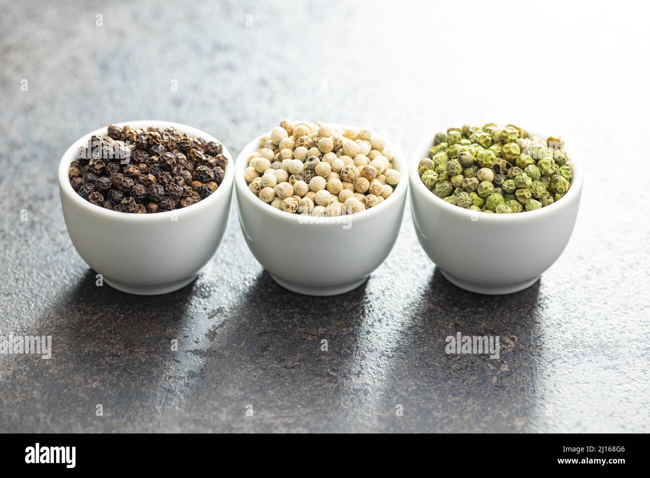 Three different types of pepper spice. Green, white and black