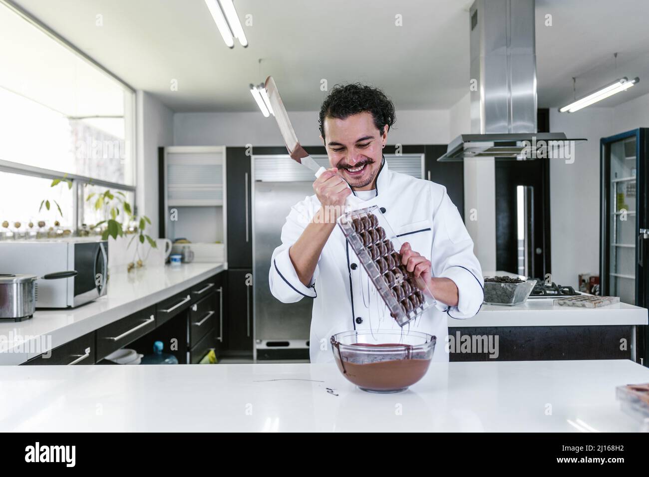 young latin man chocolatier in chef hat standing with mexican