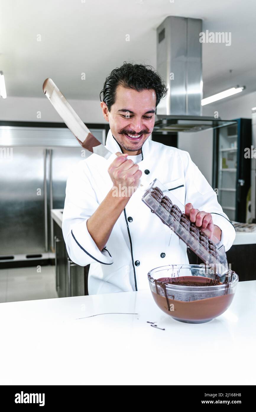 young latin man chocolatier in chef hat standing with mexican
