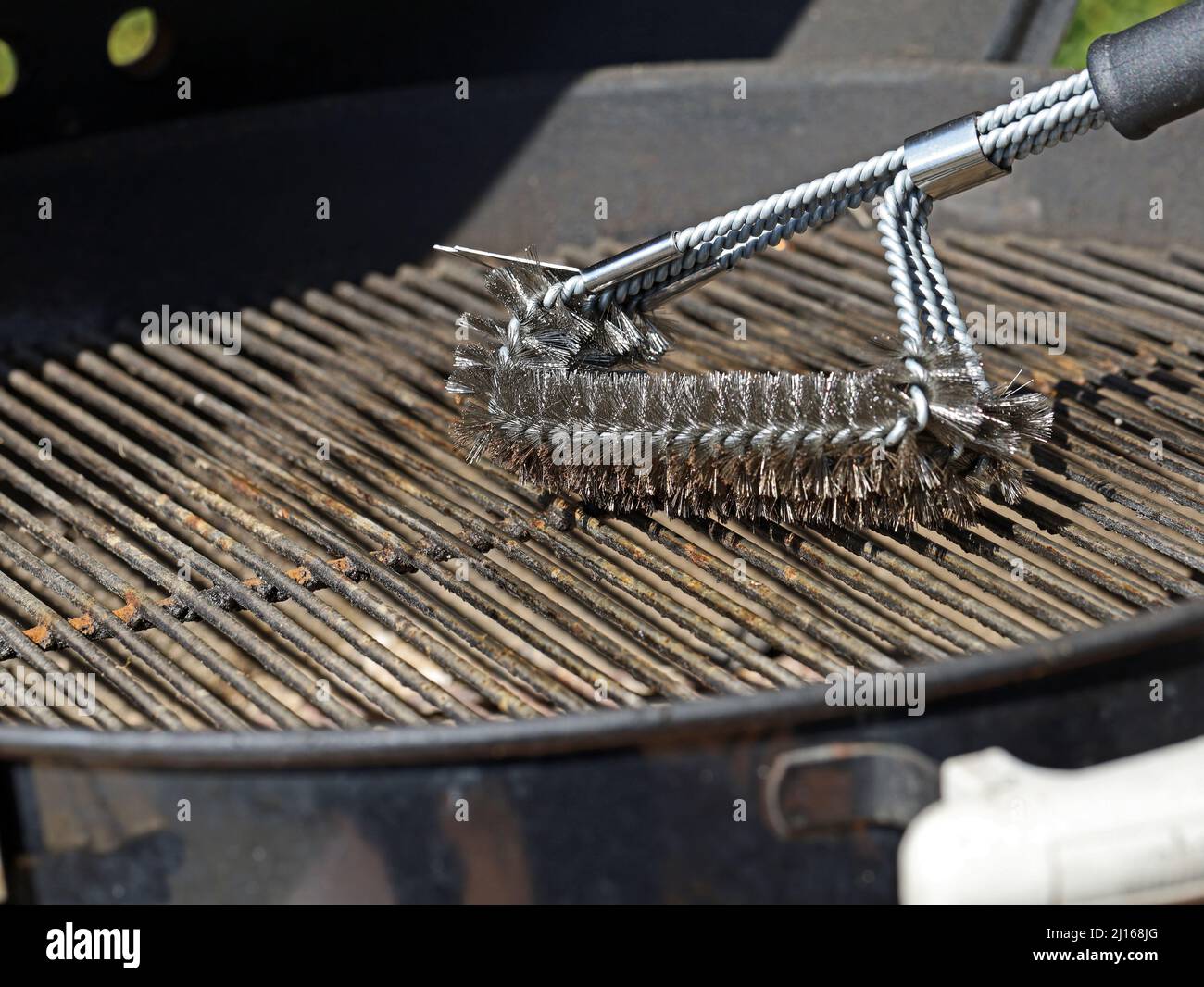https://c8.alamy.com/comp/2J168JG/cleaning-a-grill-dirty-grill-grate-is-cleaned-with-stainless-steel-grill-brush-2J168JG.jpg