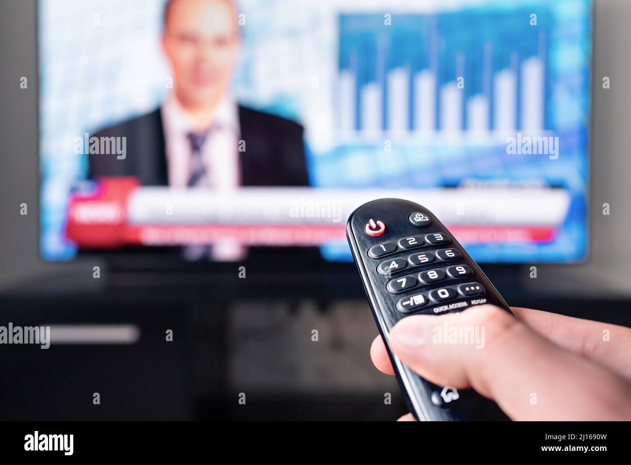 Tv news reporter in television screen and remote control. Man watching presenter, anchor or newsreader in studio. Breaking newstcast channel. Stock Photo