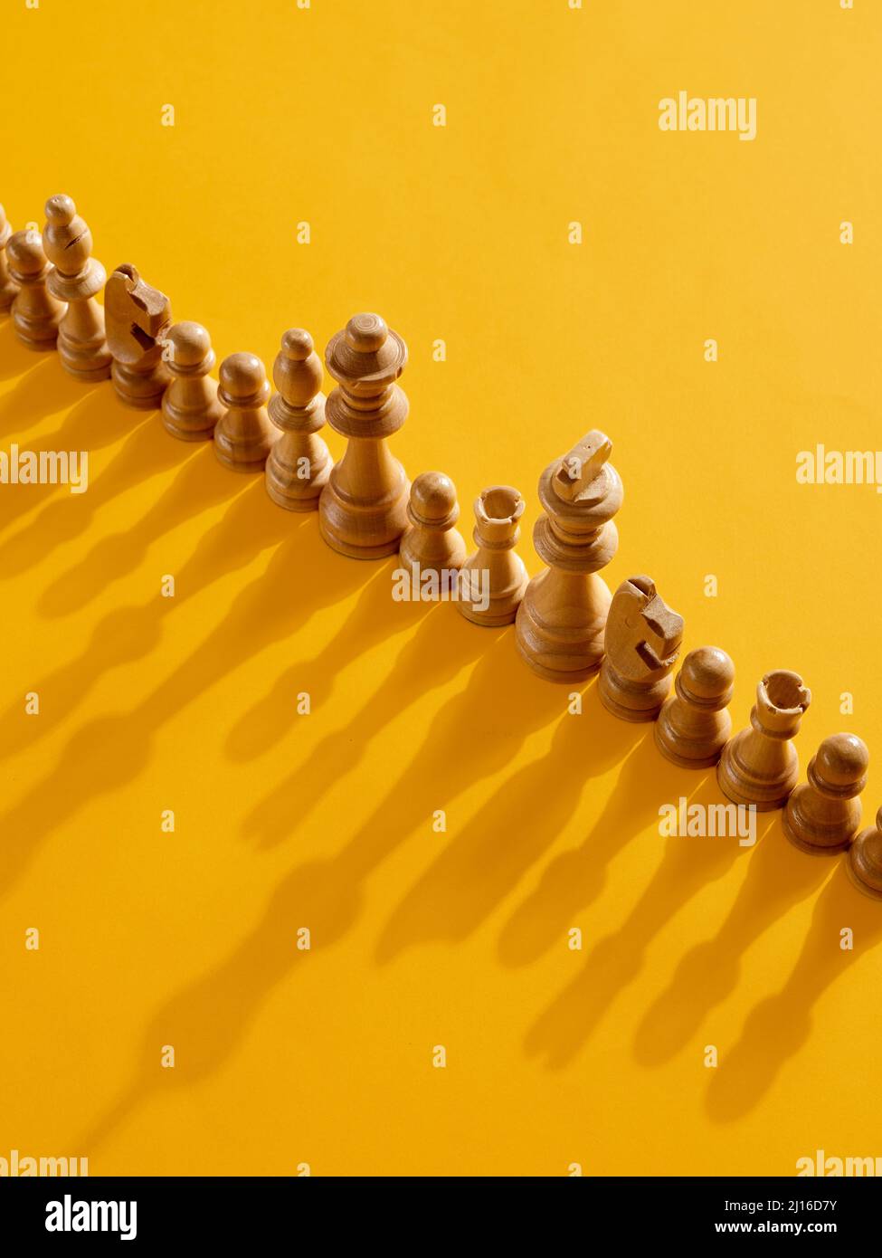 Chess piece parade ceremony on yellow background. Stock Photo