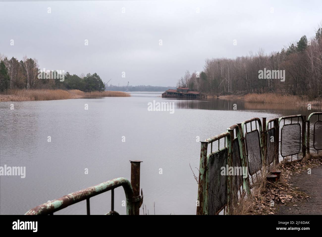 Rusty metal fence and Pripyat river in Chernobyl, Ukraine. Pripyat river and gulf near Pripyat town and Chernobyl Power Plant Stock Photo