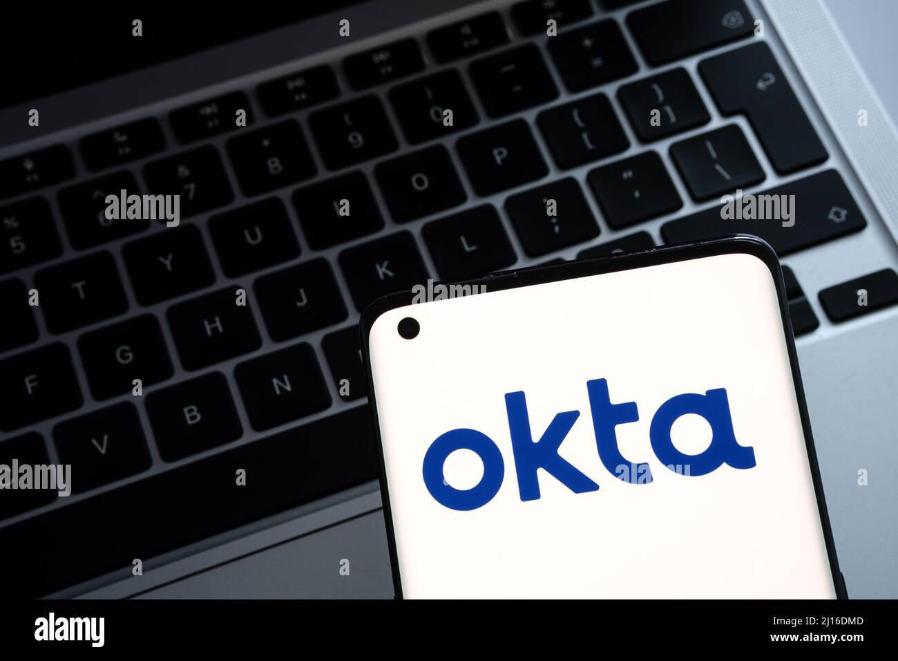 Okta security firm logo seen on smartphone and a laptop on blurred background. Concept for hack. Stafford, United Kingdom, March 22, 2022. Stock Photo