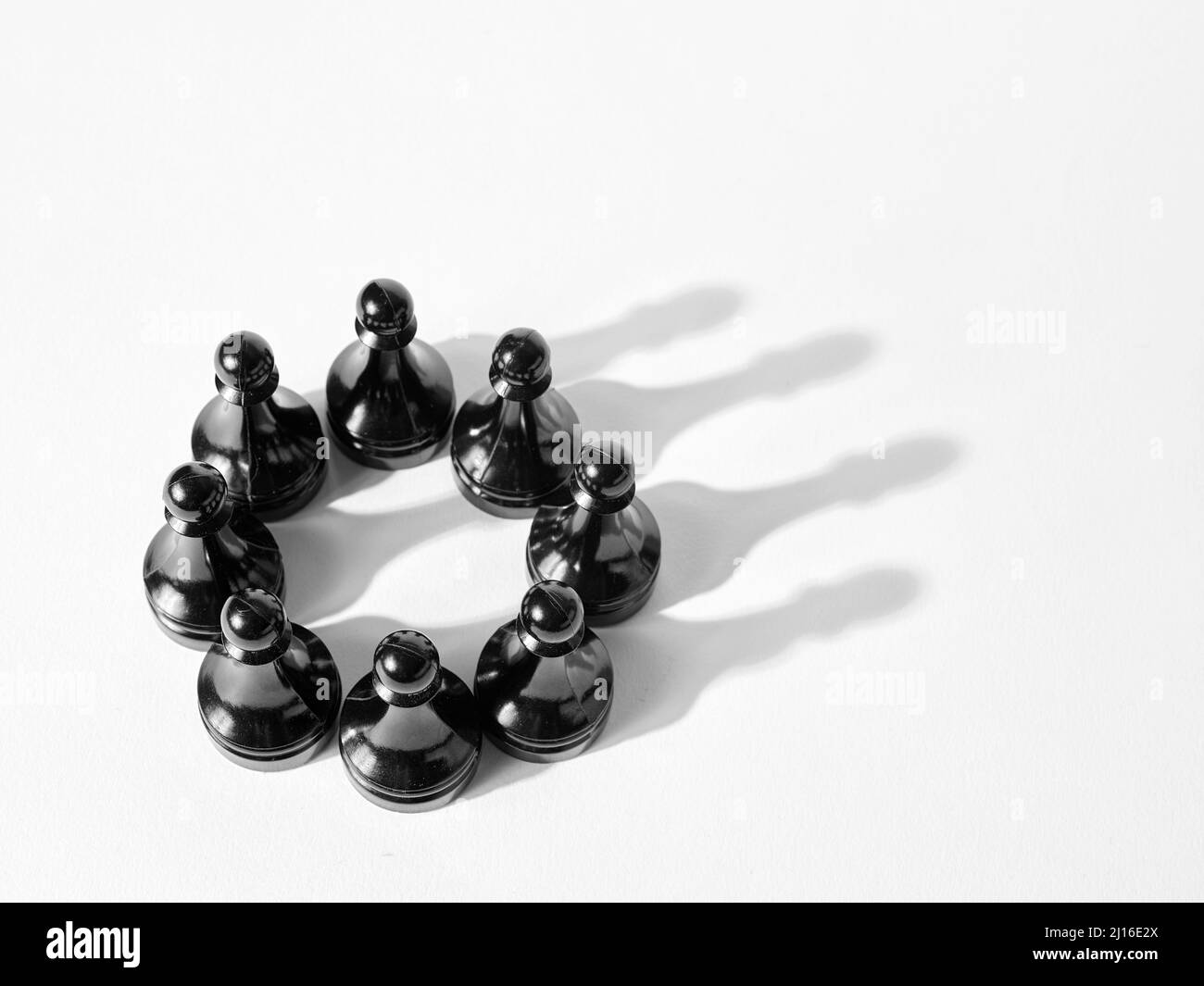 Chess pawns organized together and forming a crown shadow. Business teamwork leadership and synergy concept. Stock Photo