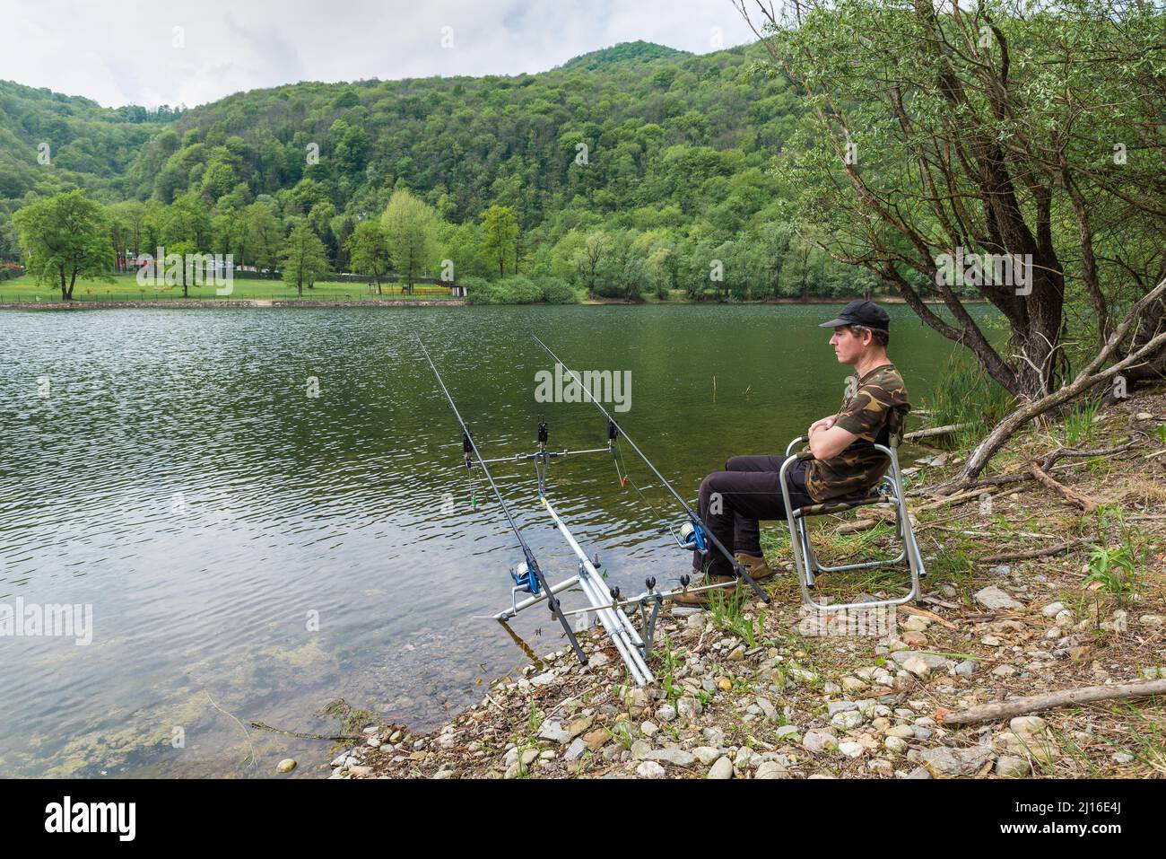 Fishing adventures, carp fishing. Man rests waiting to catch a fish with the carpfishing technique Stock Photo