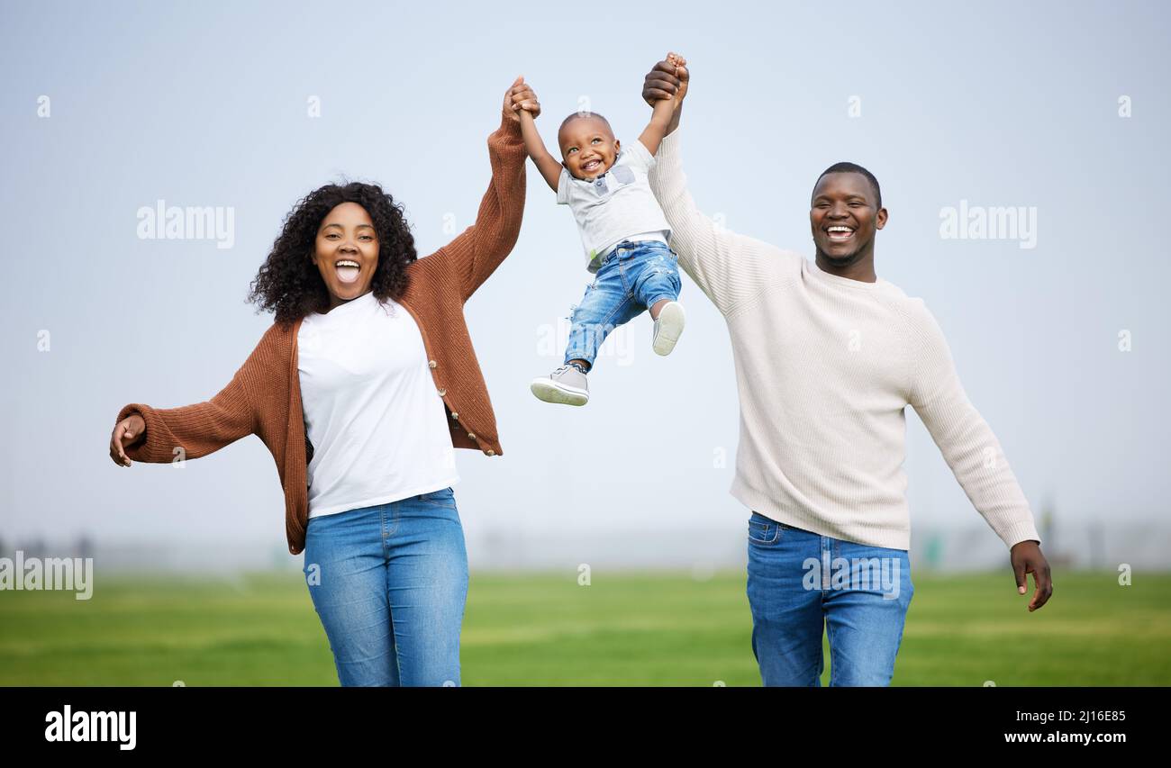 Blood is thicker than water. Shot of a young couple playing with their son in a park. Stock Photo