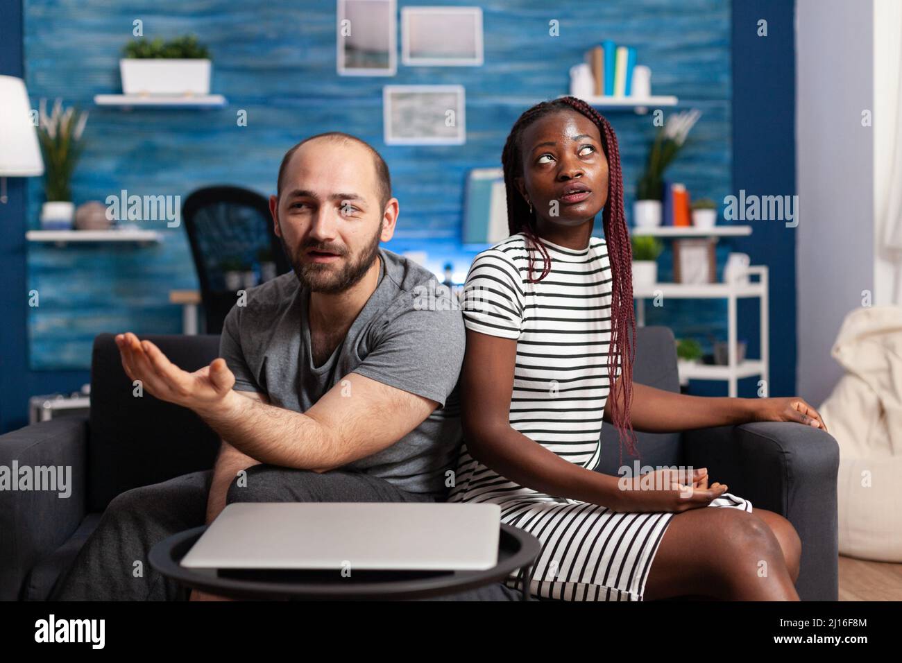 Multiethnic married couple having a dispute on sofa in living room ...