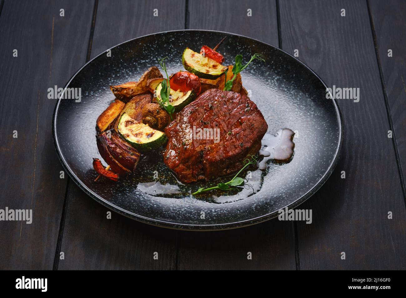 Juicy beef steak with potato wedges and grilled vegetables on skewer Stock Photo