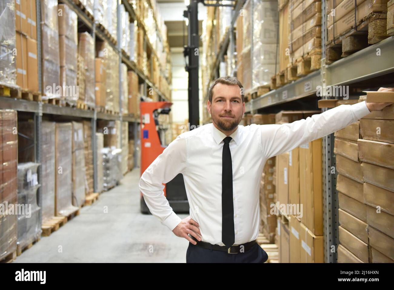 portrait friendly businessman/ manager in suit working in the warehouse of a company Stock Photo