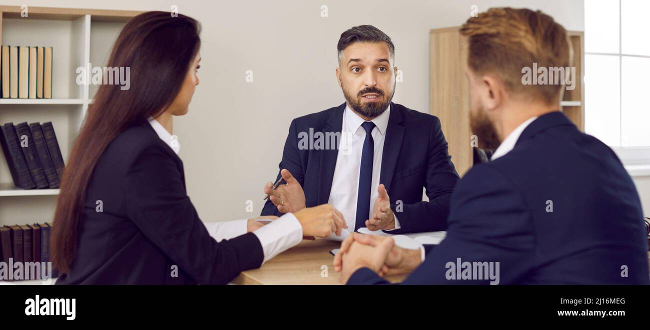 Investment broker, financial advisor, bank employee or lawyer advises married couple. Stock Photo