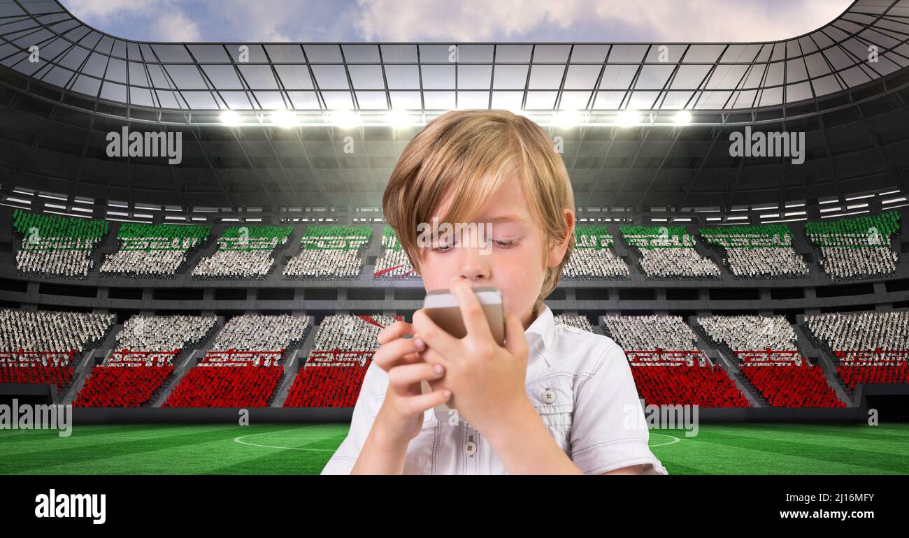 Composite image of caucasian boy using smartphone against sports stadium Stock Photo