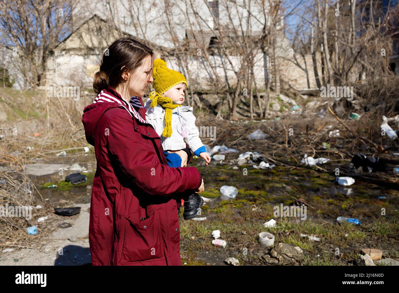 A mother and her child looking at their devastated home Stock Photo