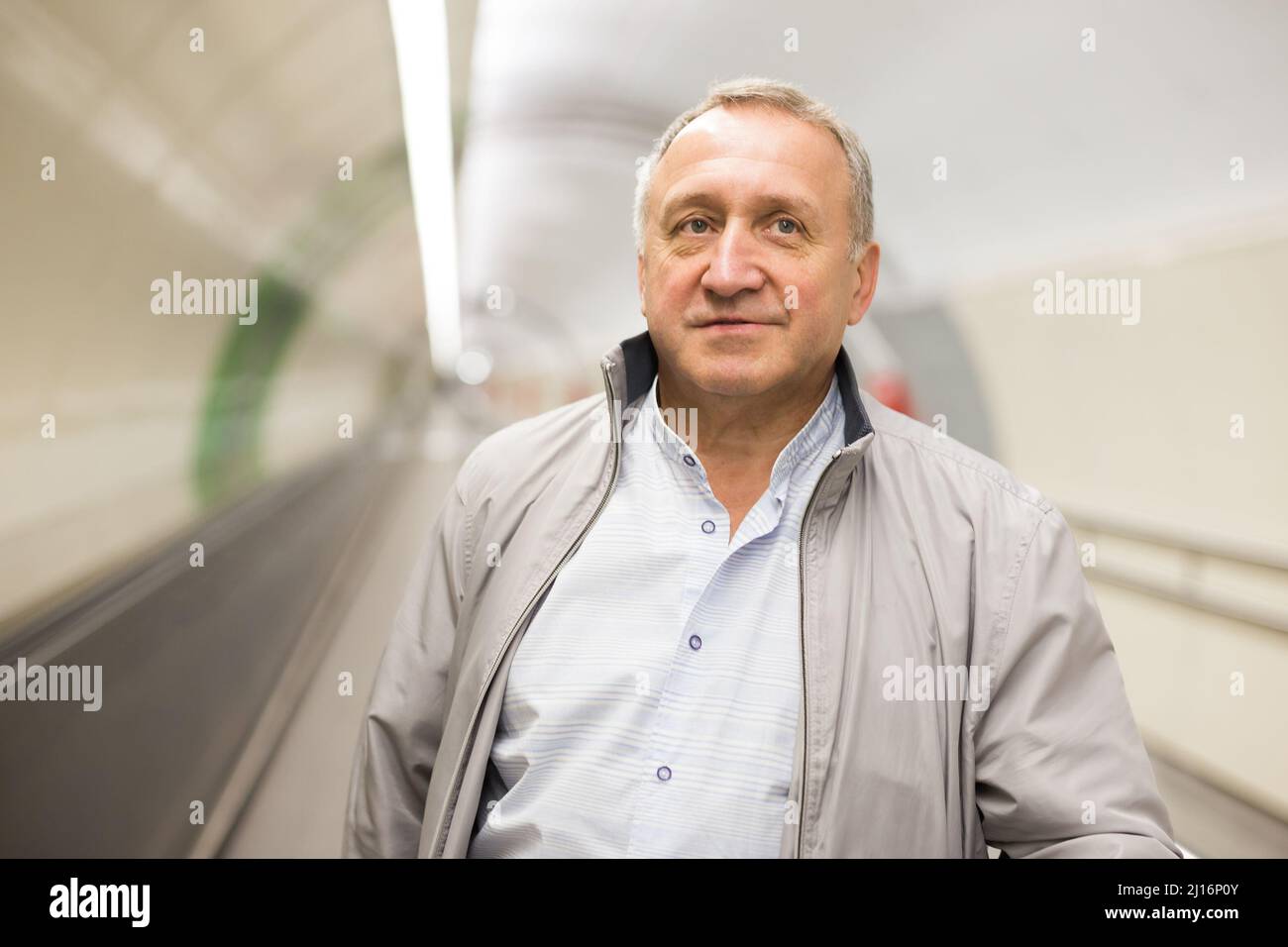 Middle aged man on moving walkway Stock Photo