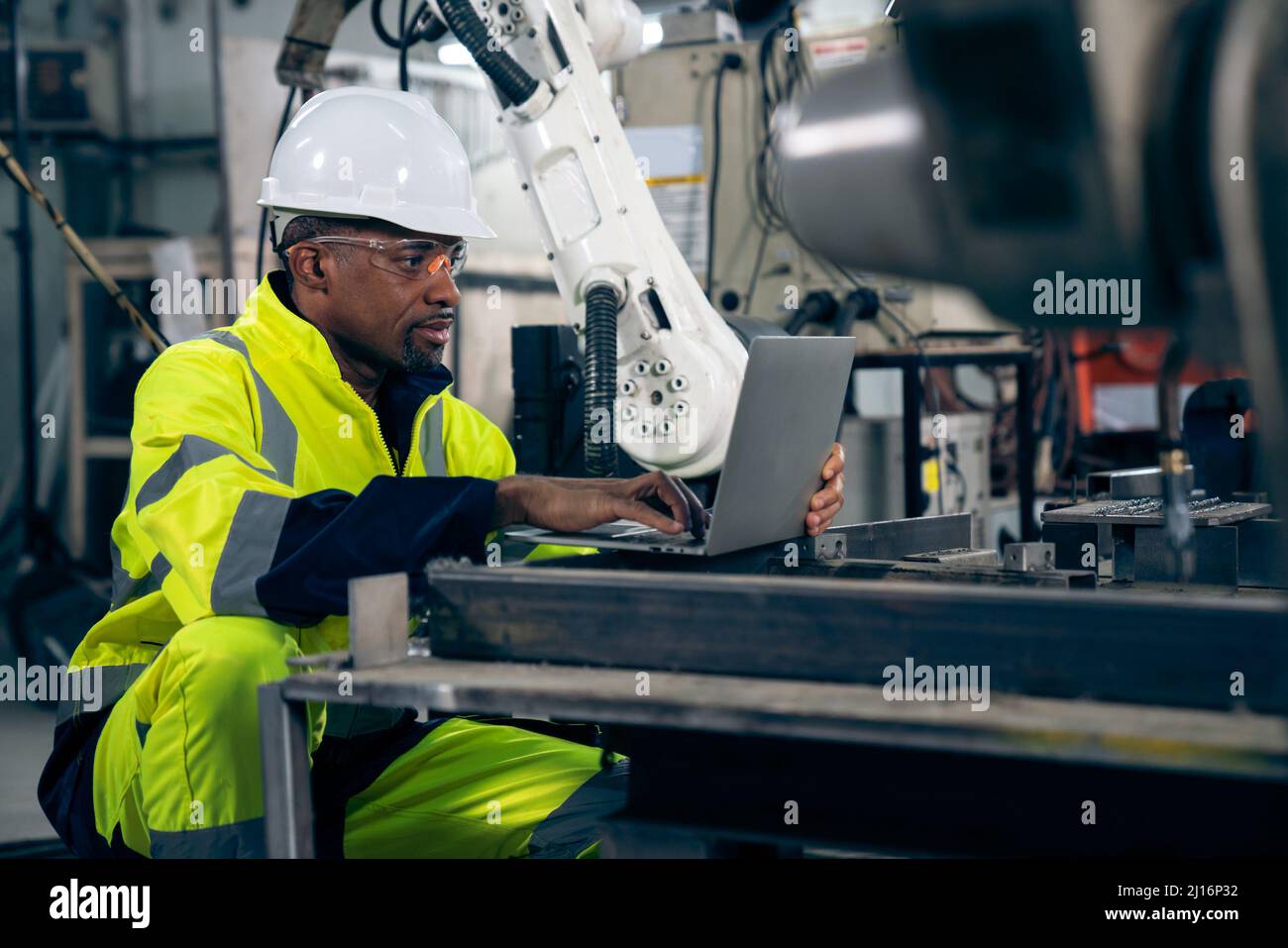 Factory worker working with laptop computer to do adept procedure