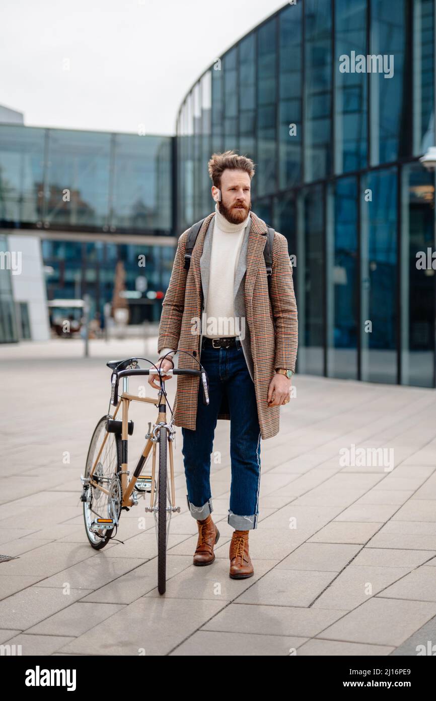 Young Business Manager going to work on bike. Eco friendly transport. Vertical image Stock Photo