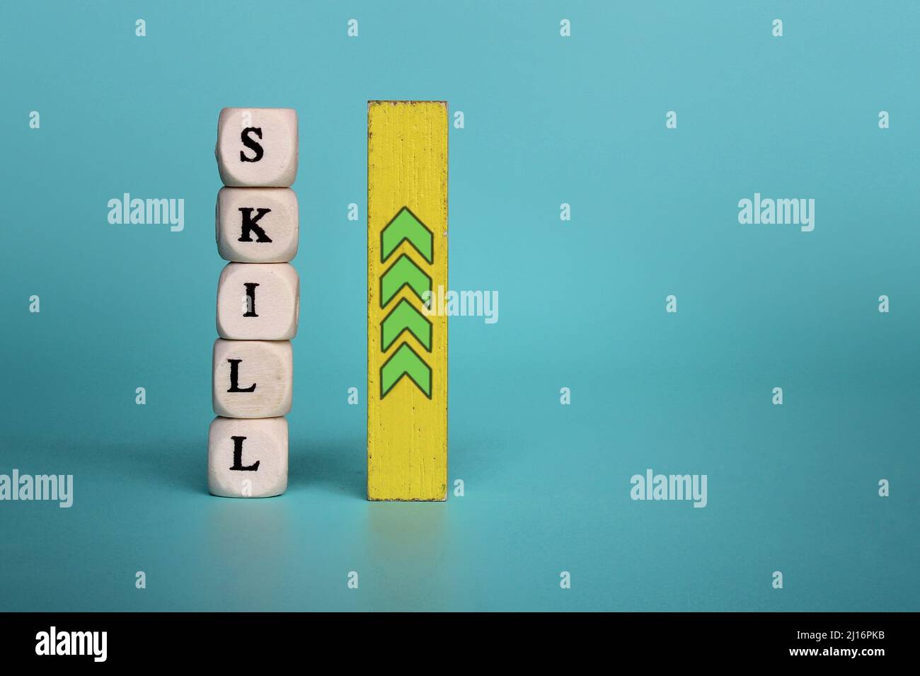 Wooden cubes with text SKILL and wooden tile with upward arrow. Copy space. Upgrade skill concept. Stock Photo