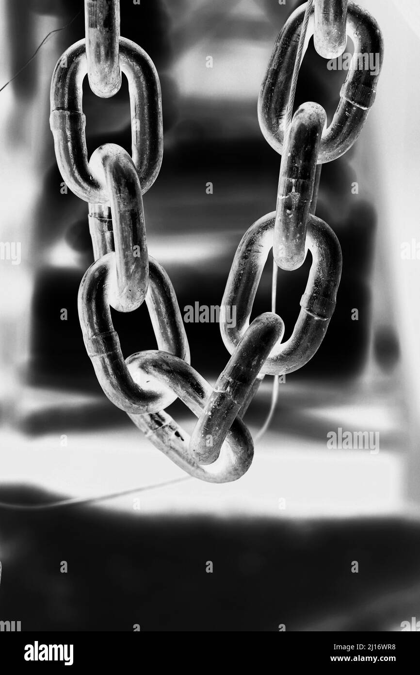 Closeup of a heavy chain with industrial metal links hanging down in