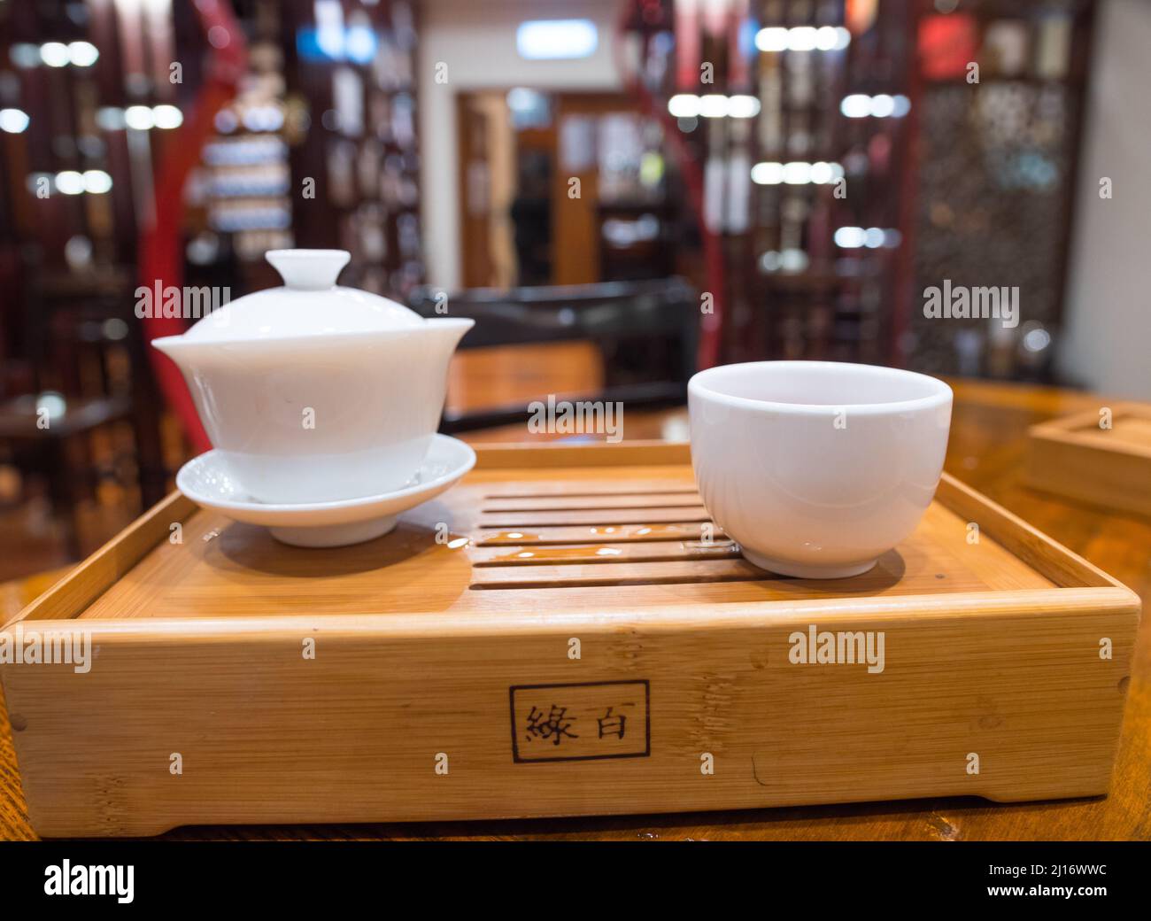 Gong Fu Cha brewing. Beautiful white porcelain (Gaibei/ Gaiwan & tea cup) set on a bamboo tray. Perfect for tea tasting. Lock Cha Tea House, Hong Kong Stock Photo