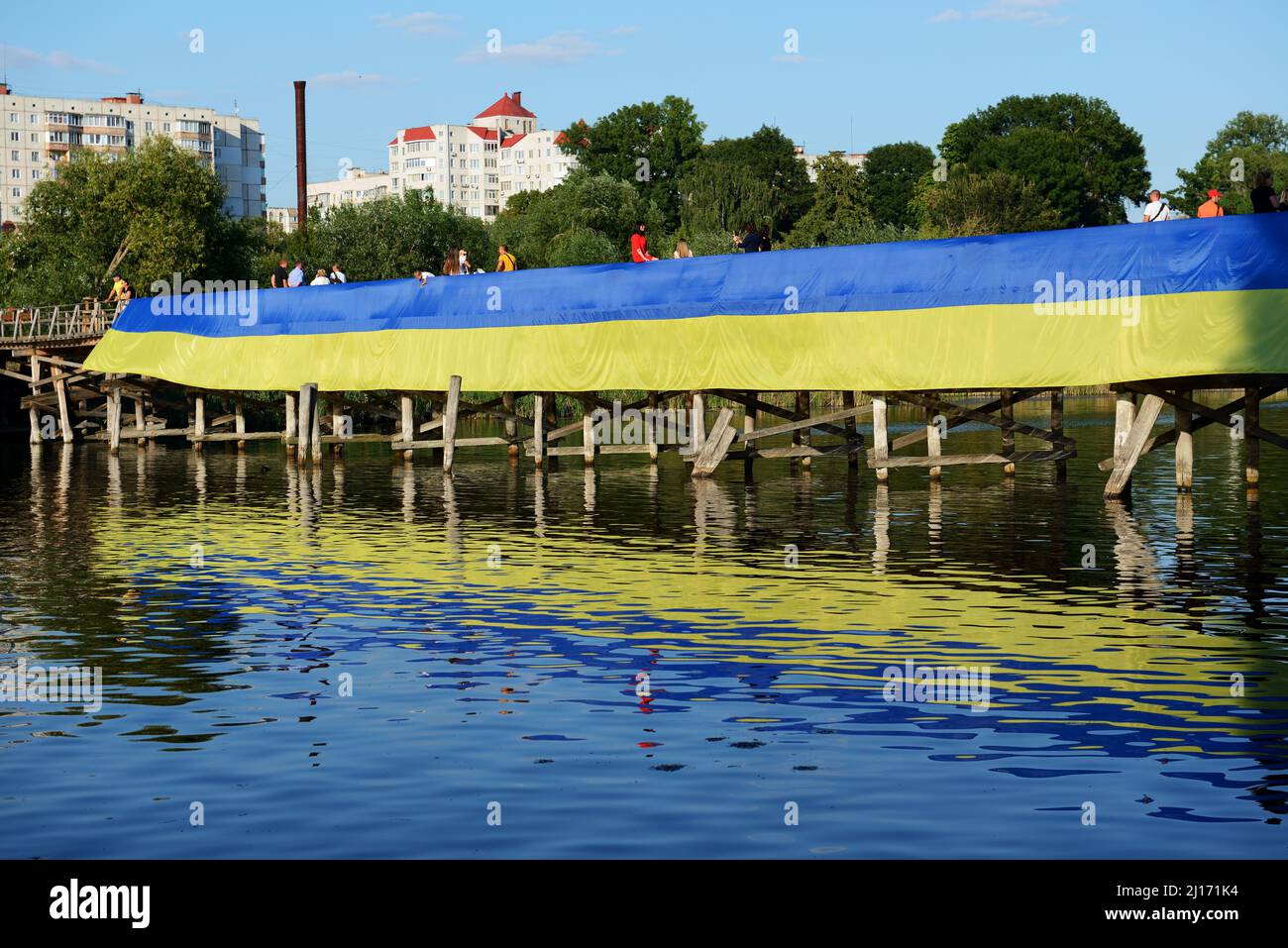 BILA TSERKVA, UKRAINE - AUGUST 22: The view on Ukrainian National Flag dedicated to Ukrainian Independence Day wich lays on wooden bridge over Ros riv Stock Photo