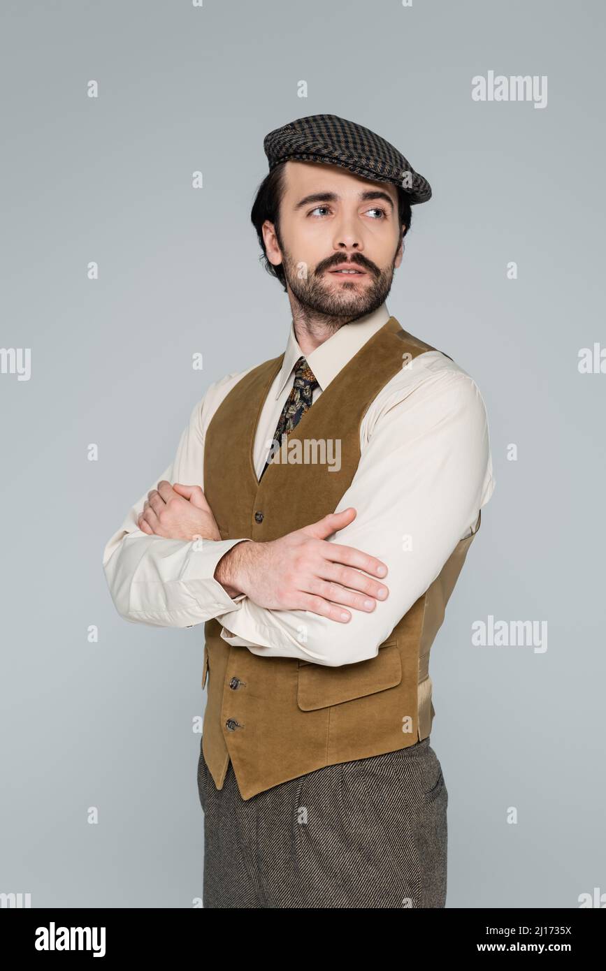 man with mustache and vintage style clothing standing with crossed arms ...