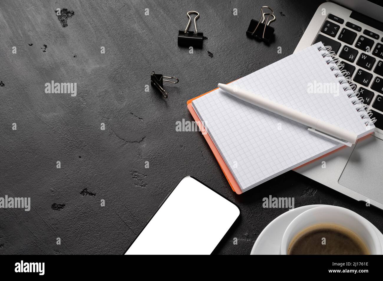 Notepad is on top of office desk table with laptop and supplies Stock