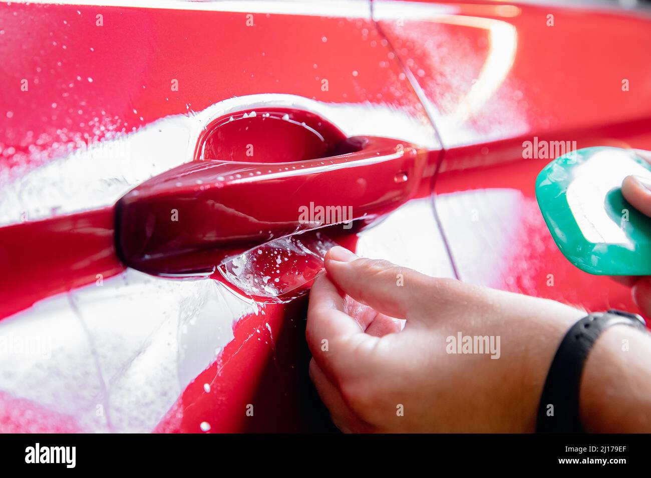 Paint protection is vinyl film in zone risk under handles red car Stock