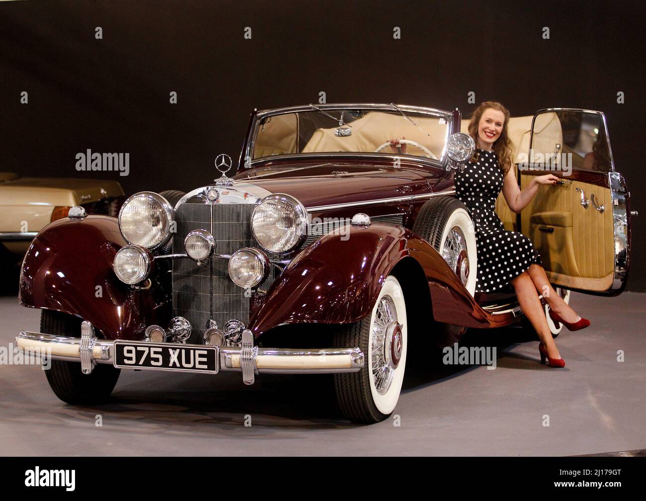 Essen, Germany. 23rd Mar, 2022. A model has taken a seat in the Mercedes Benz Cabriolet C (1937) of the former King Faruk of Egypt. At the Techno-Classica from 23 to 27.03.2022 at the Essen fair will be shown about 2700 exhibits in all eight halls. Credit: Roland Weihrauch/dpa/Alamy Live News Stock Photo