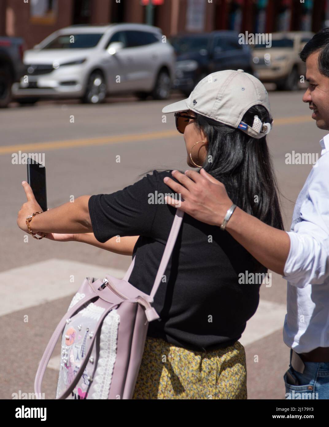 A couple visiting Santa Fe, New Mexico, take a souvenir selfie portrait with their smartphone. Stock Photo