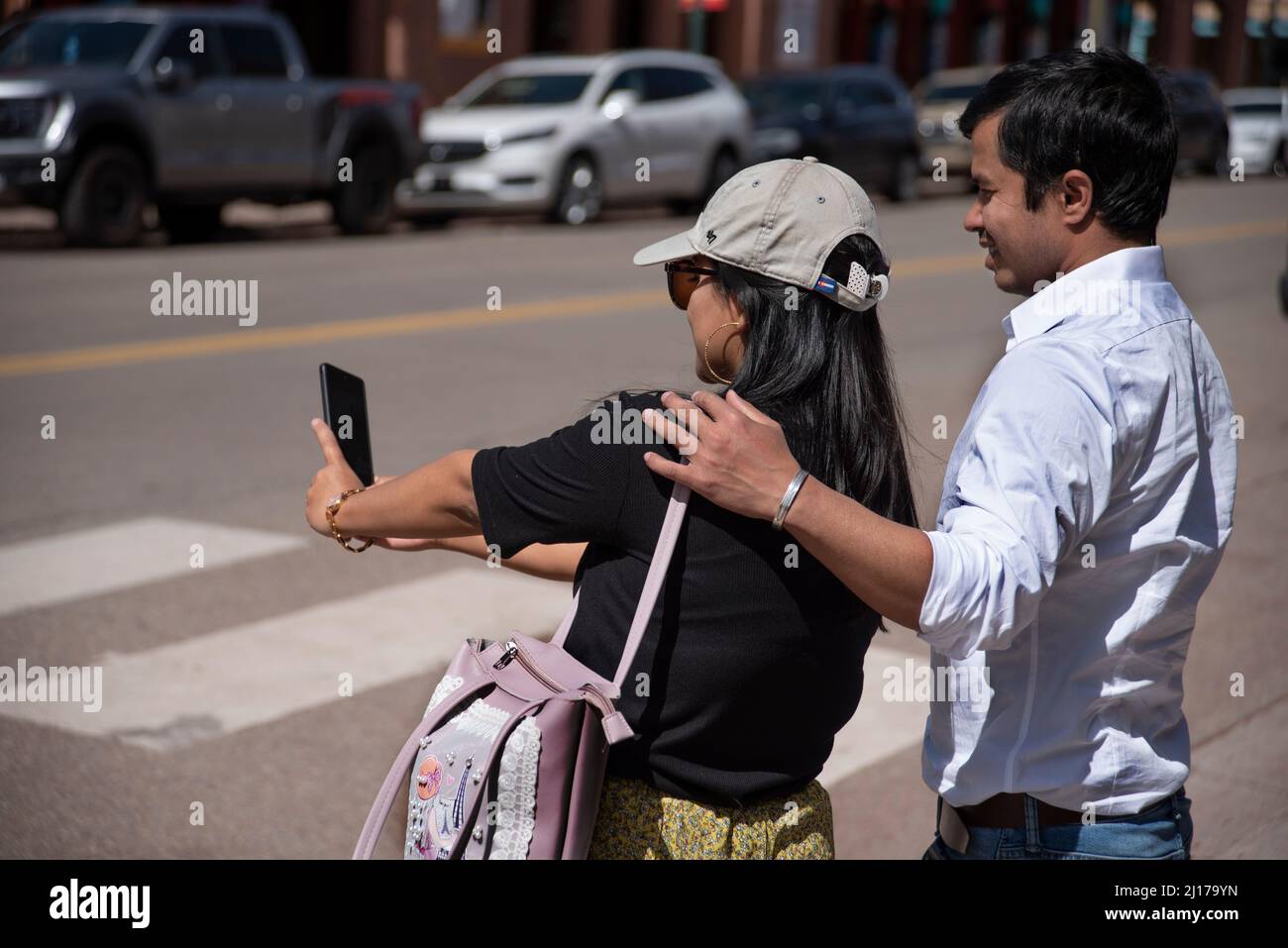 A couple visiting Santa Fe, New Mexico, take a souvenir selfie portrait with their smartphone. Stock Photo