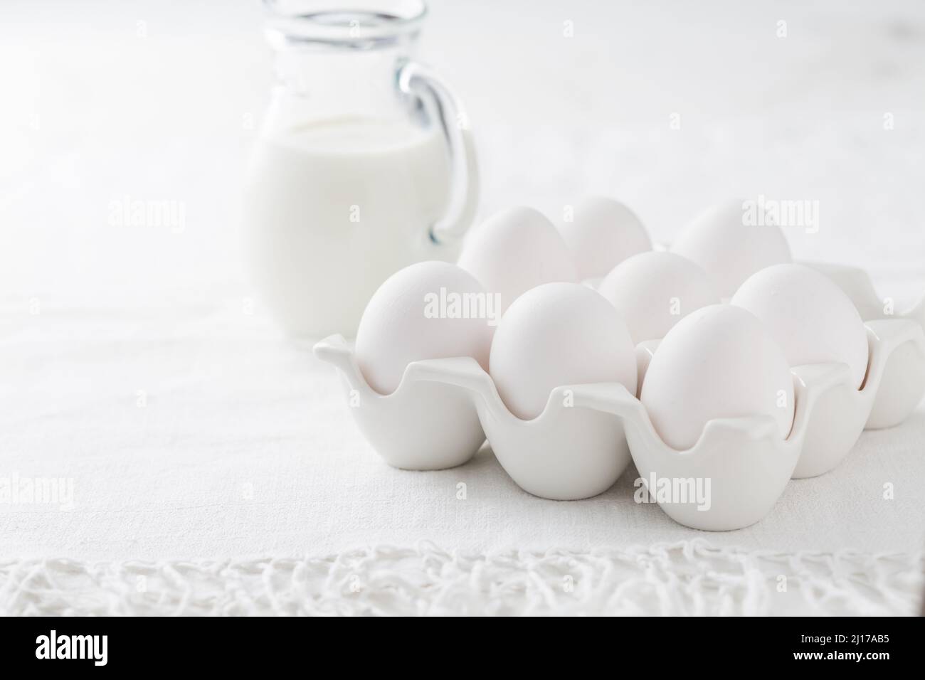 Organic milk and fresh eggs on white kitchen table Stock Photo