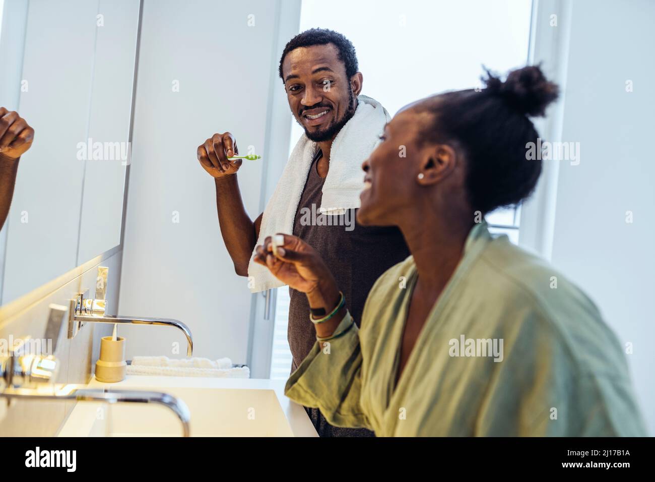 Happy couple brushing teeth in bathroom Stock Photo