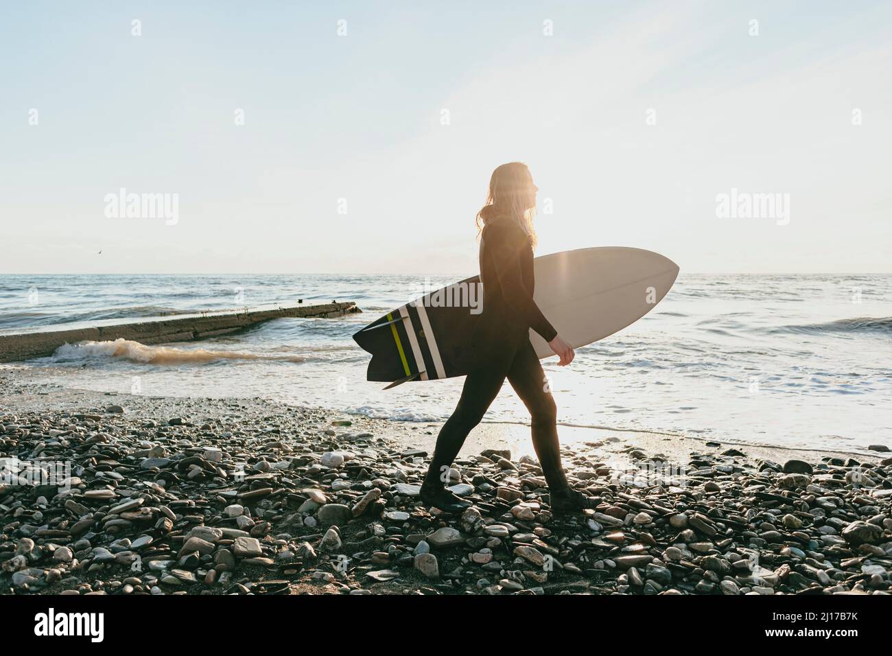 Surfer with surfboard walking on beach Stock Photo