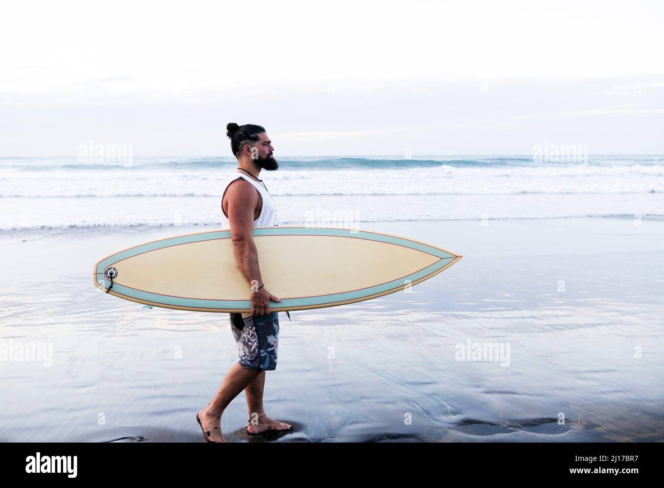 Bearded man surfboard walking at beach Stock Photo