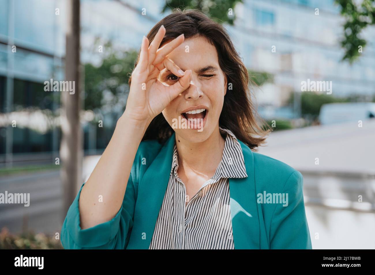 Happy businesswoman in smart casuals making ok gesture sign with hand Stock Photo