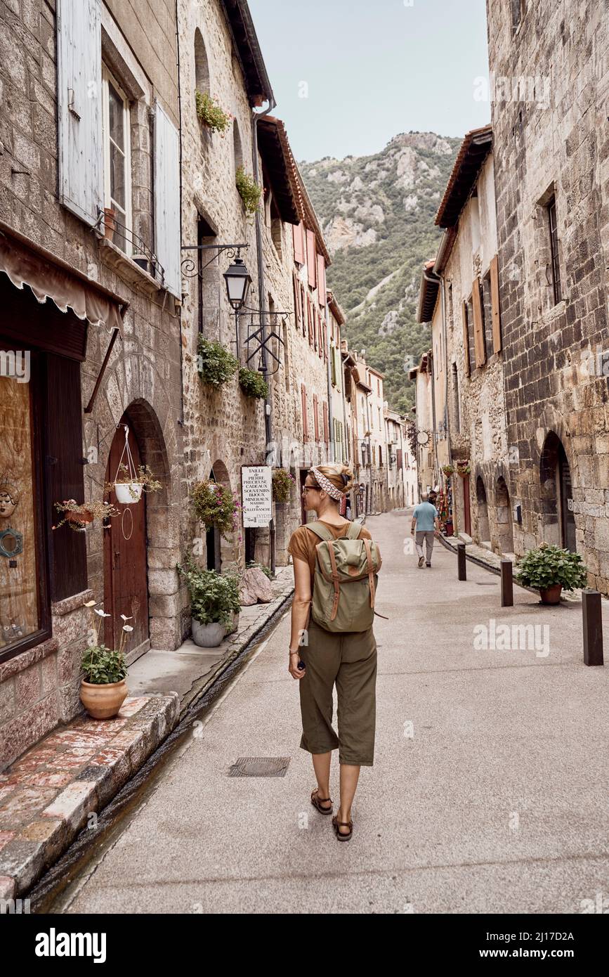 Woman with backpack walking in Villefranche-de-Conflent town Stock Photo